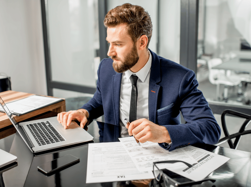 Stressed office worker staying late in a modern open plan office