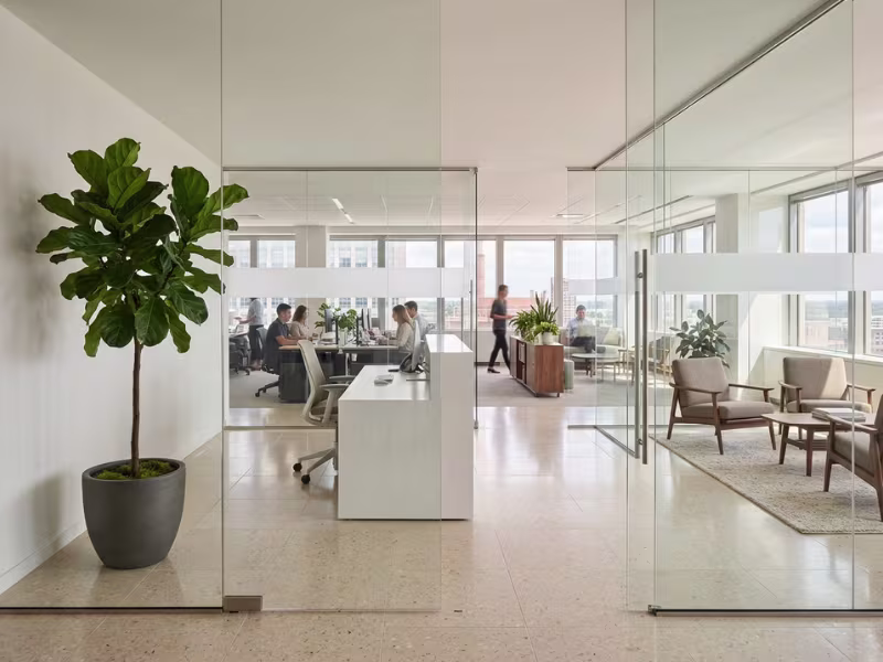 Frameless glass partition with frosted band in a reception area Frameless glass partition with frosted band in a reception area